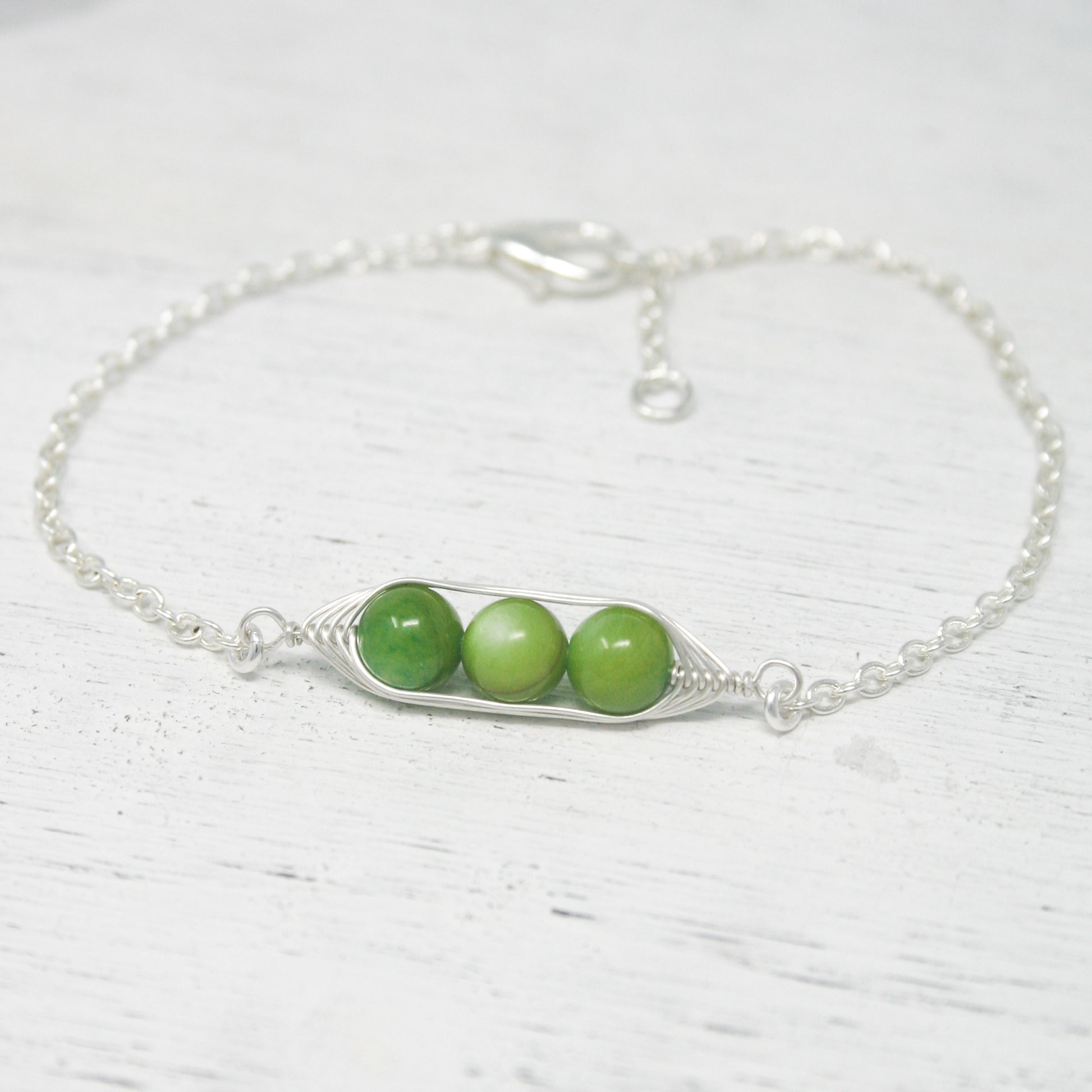 two peas in a pod on a silver chain bracelet
