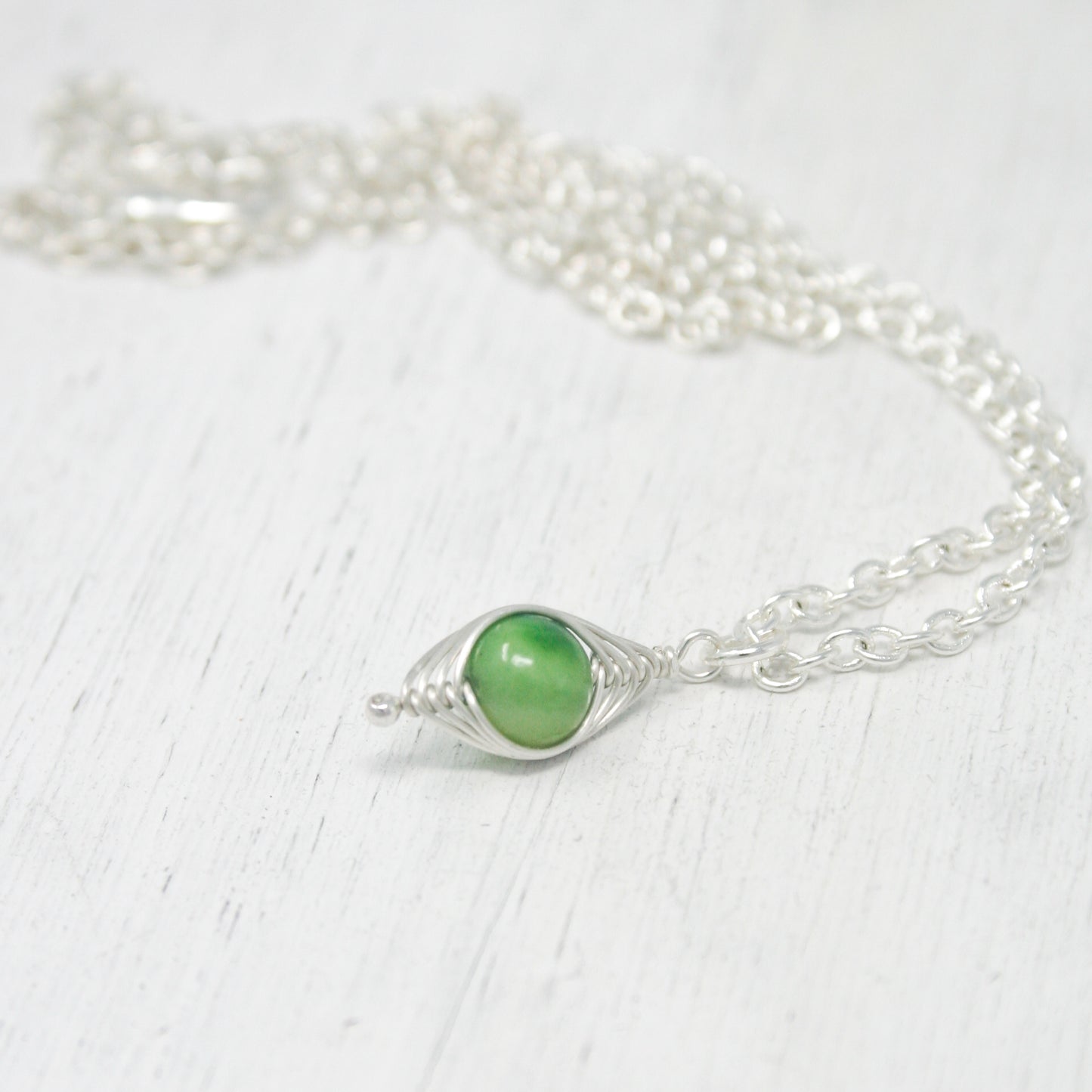 a close up of a necklace on a white surface