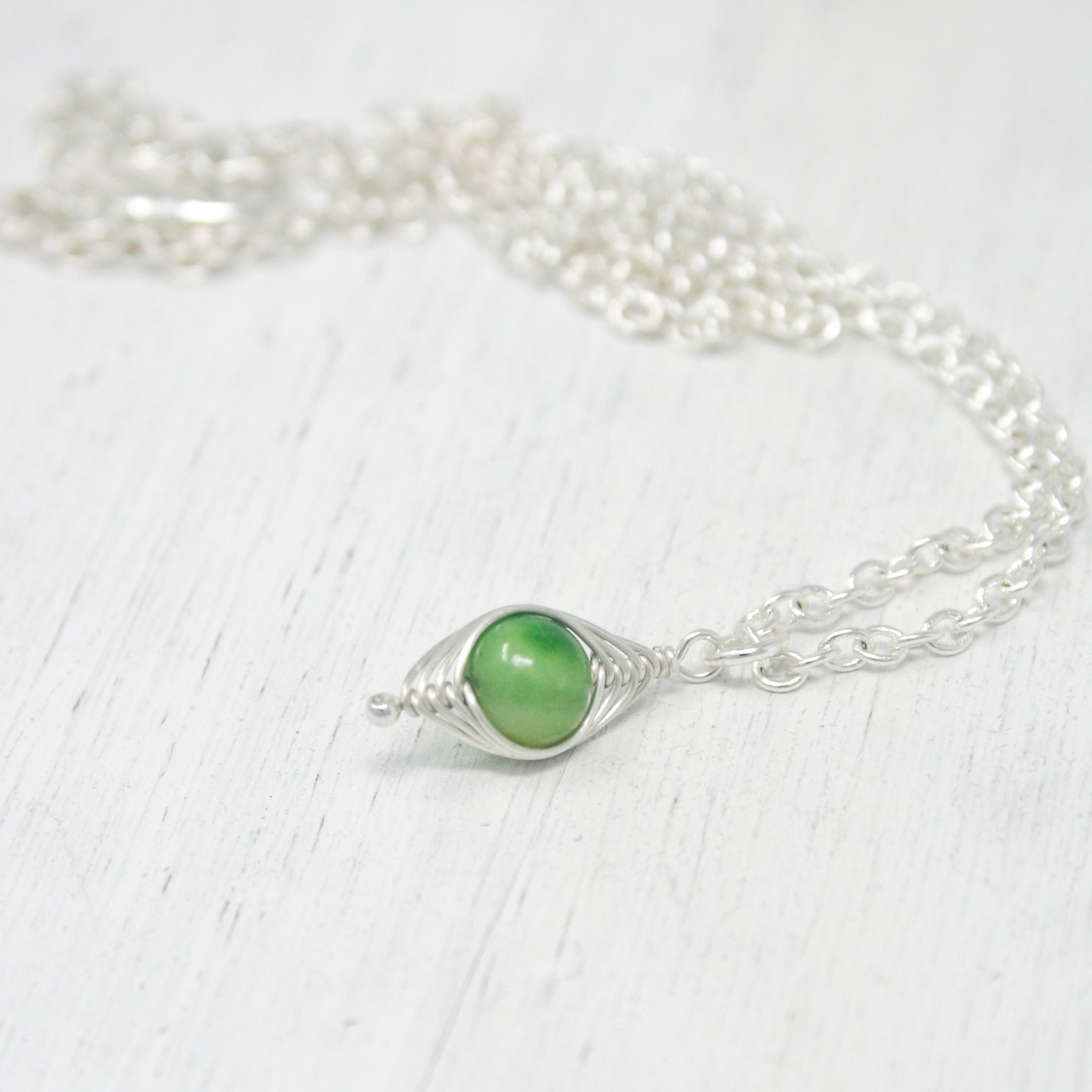 a close up of a necklace on a white surface