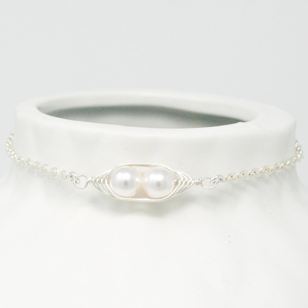 a close up of a white vase with a necklace on it