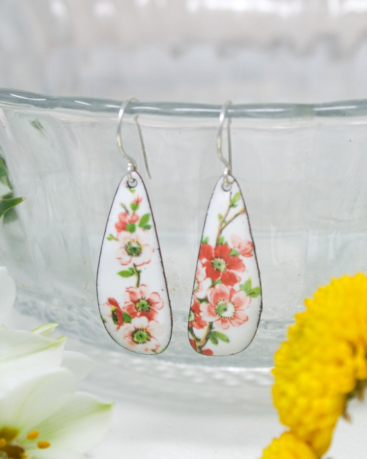 a pair of earrings with flowers painted on them