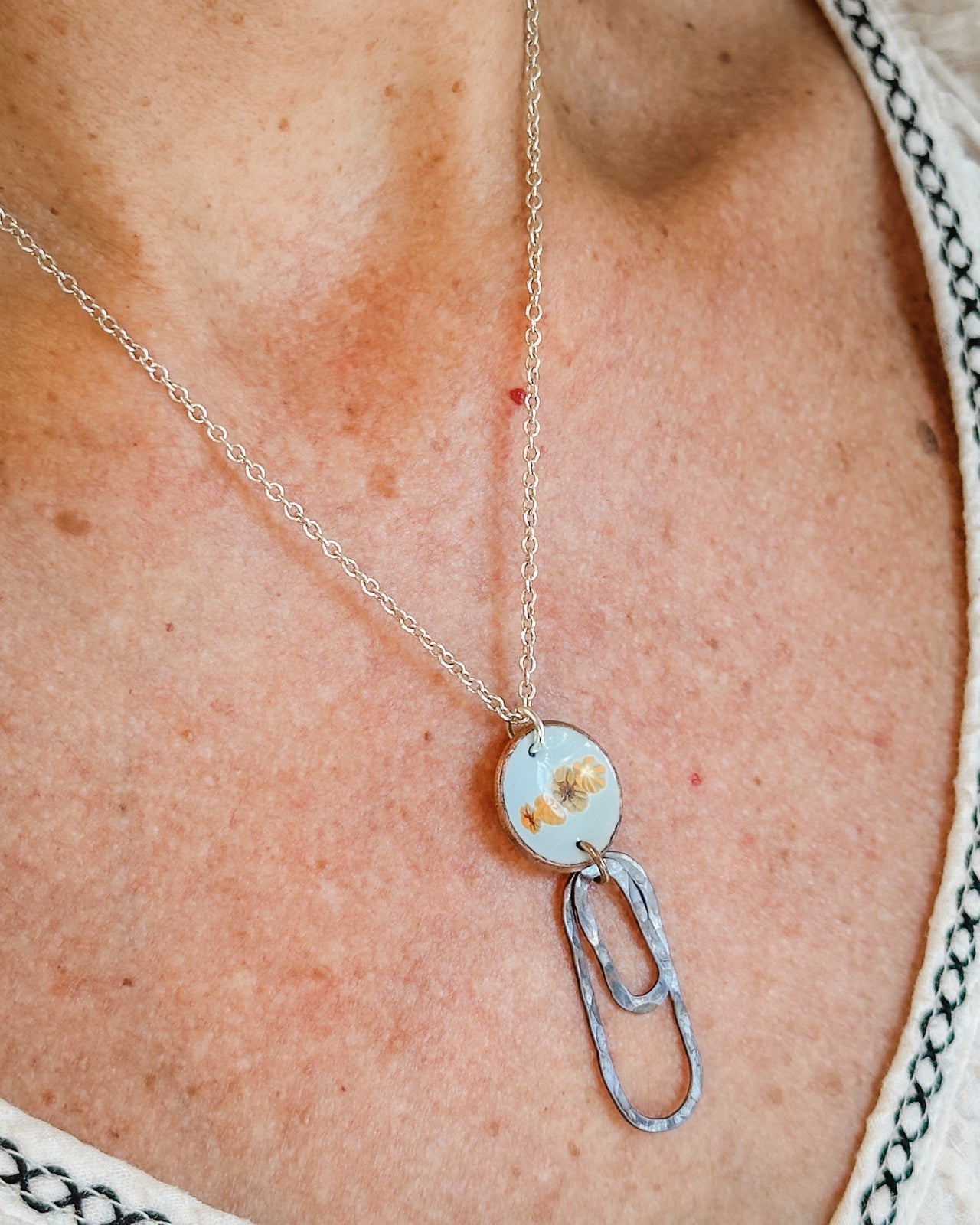 A necklace with a pendant featuring a floral design.