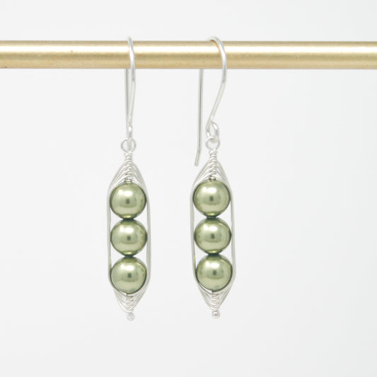 a pair of earrings with pearls hanging from them
