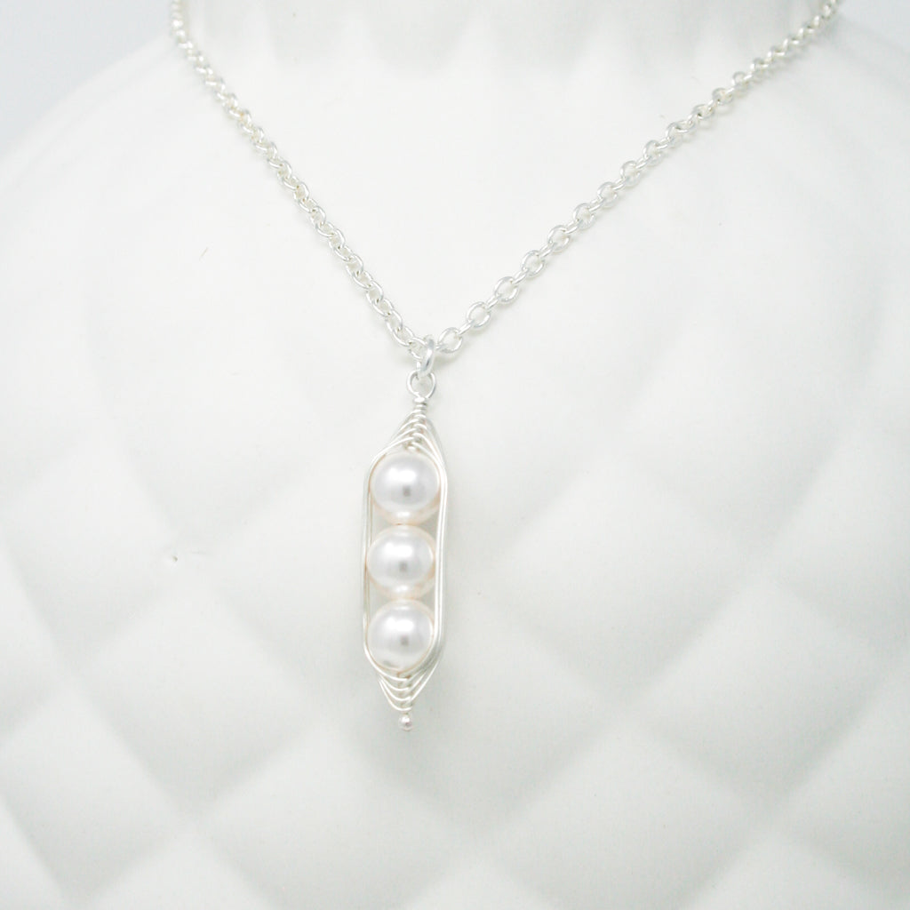 a necklace with two pearls hanging from it
