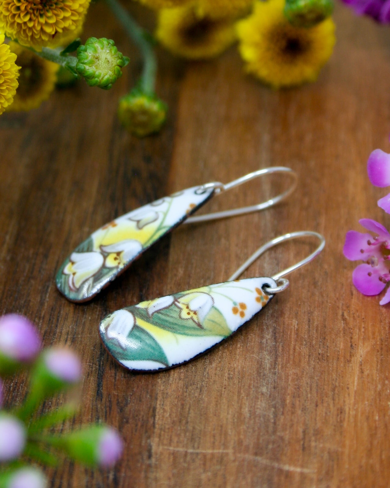 a pair of earrings sitting on top of a wooden table