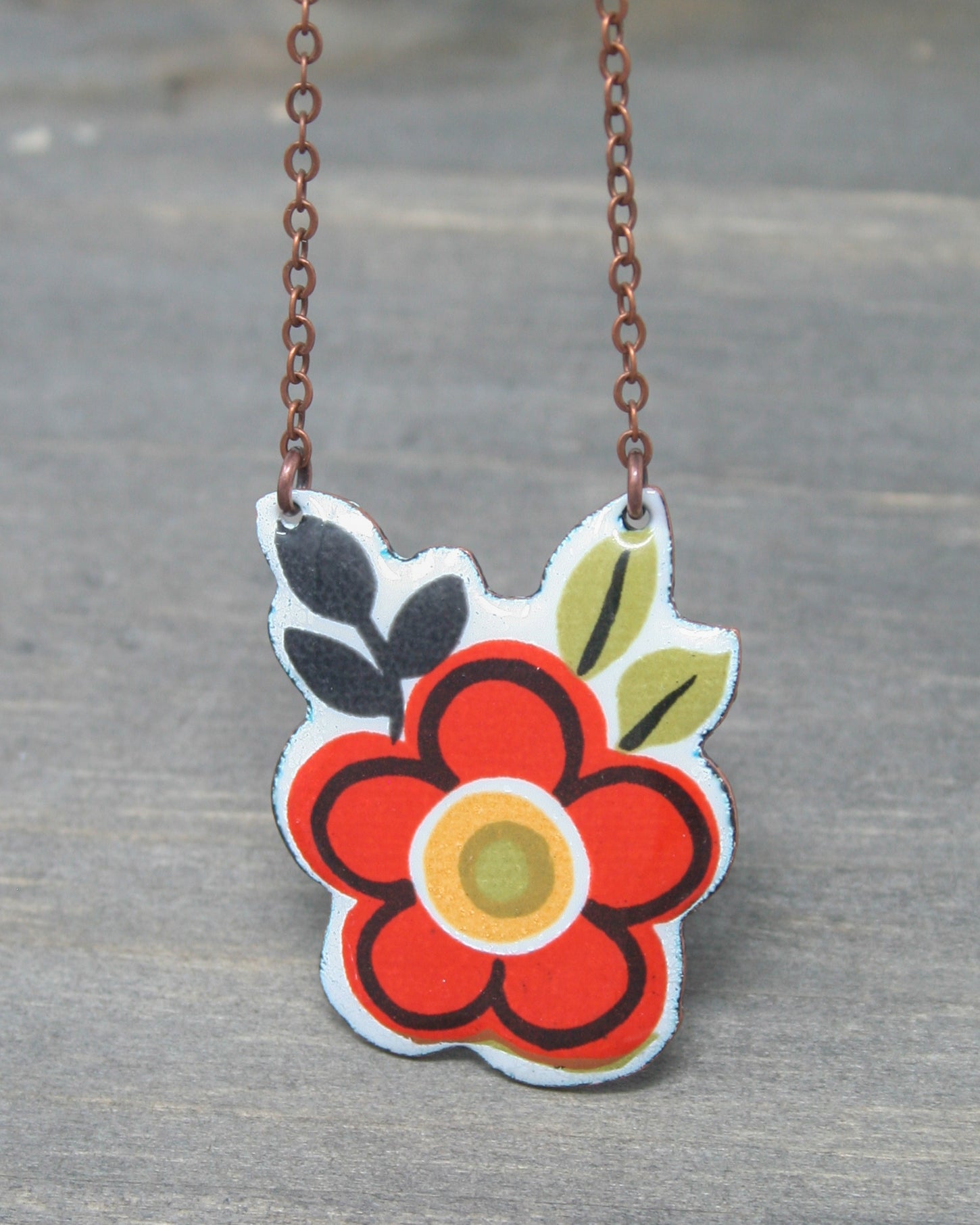 a red flower is hanging from a chain