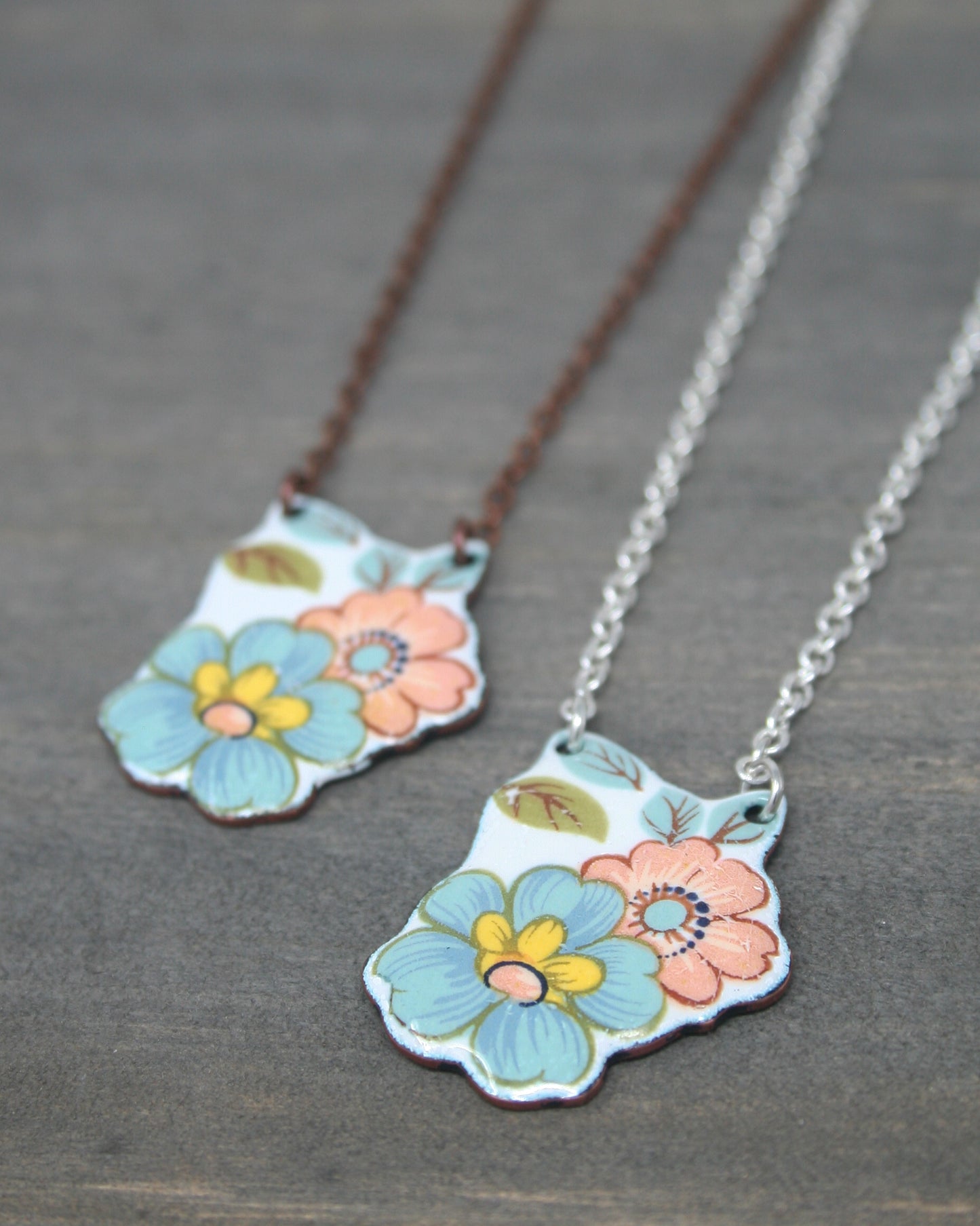 a couple of necklaces with flowers on them