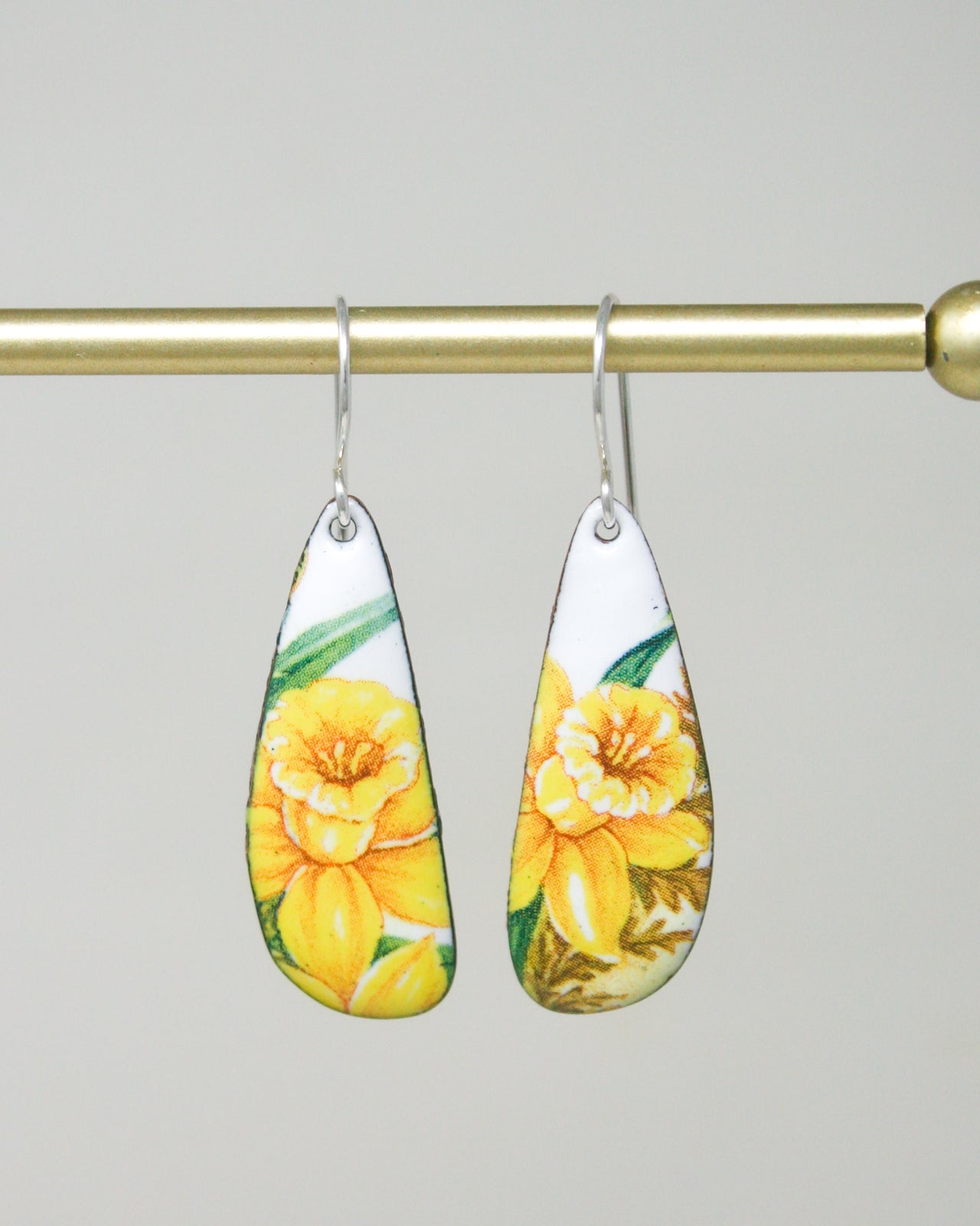 a pair of yellow flowers are hanging from a hook