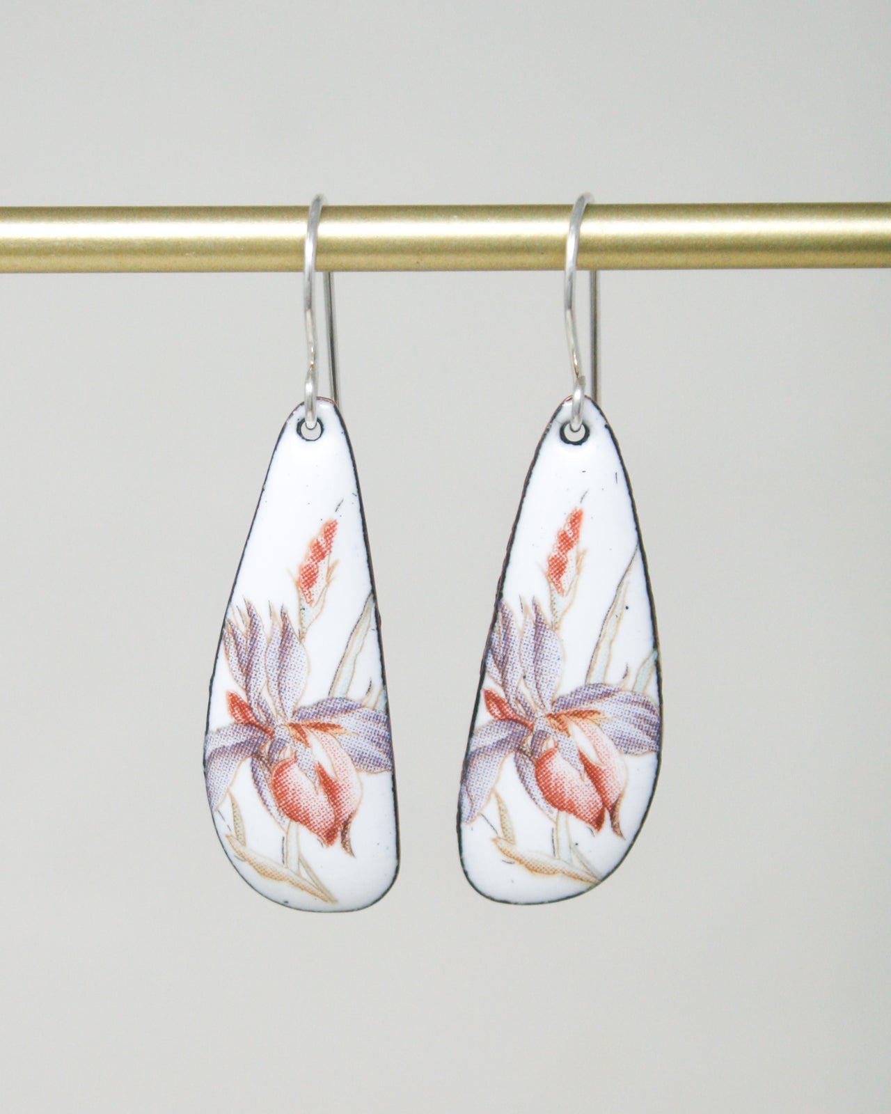 a pair of earrings with flowers painted on them