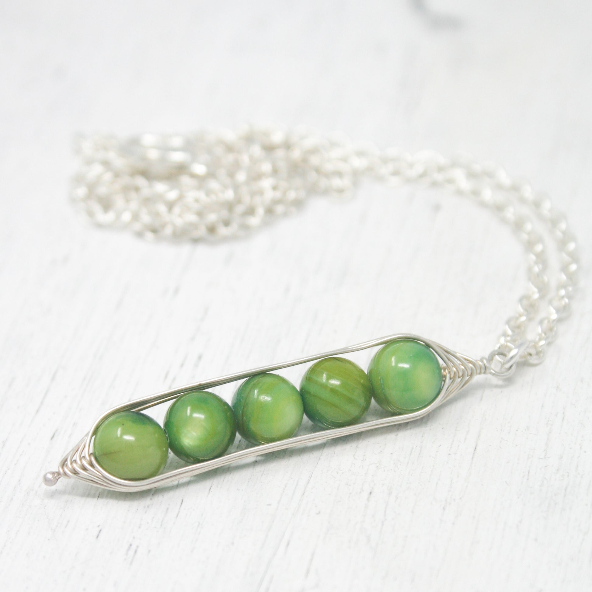 three peas in a pod on a silver chain