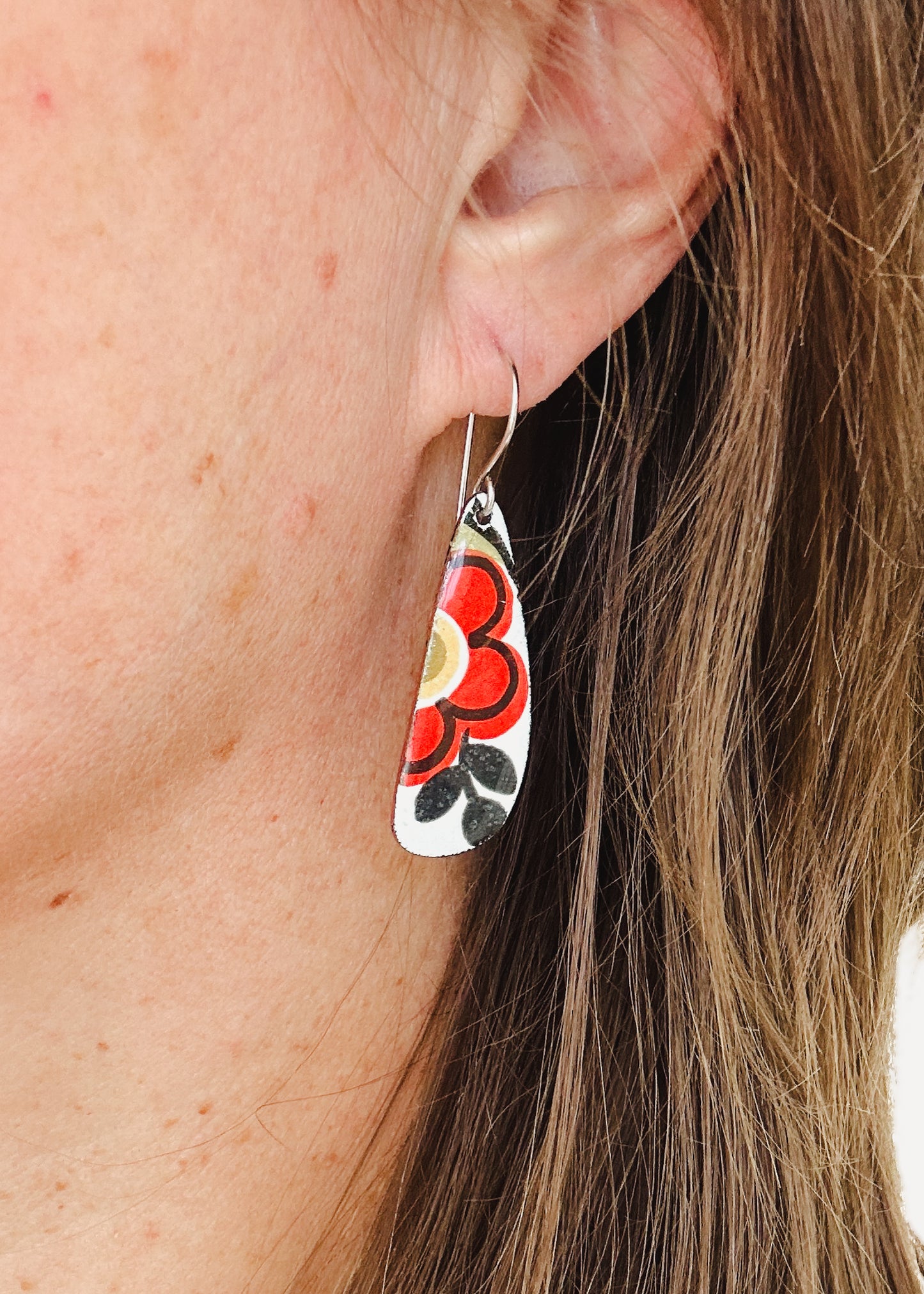 a close up of a person wearing a pair of earrings