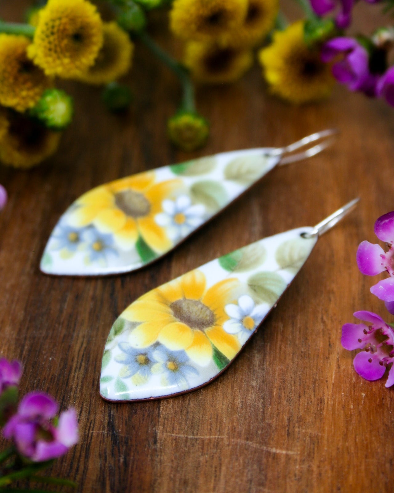 a pair of earrings with flowers painted on them