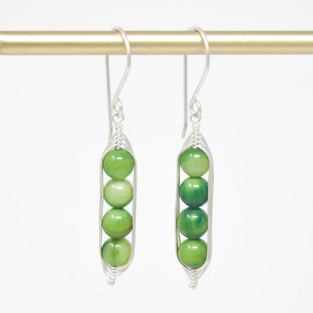 a pair of green beads hanging from a hook