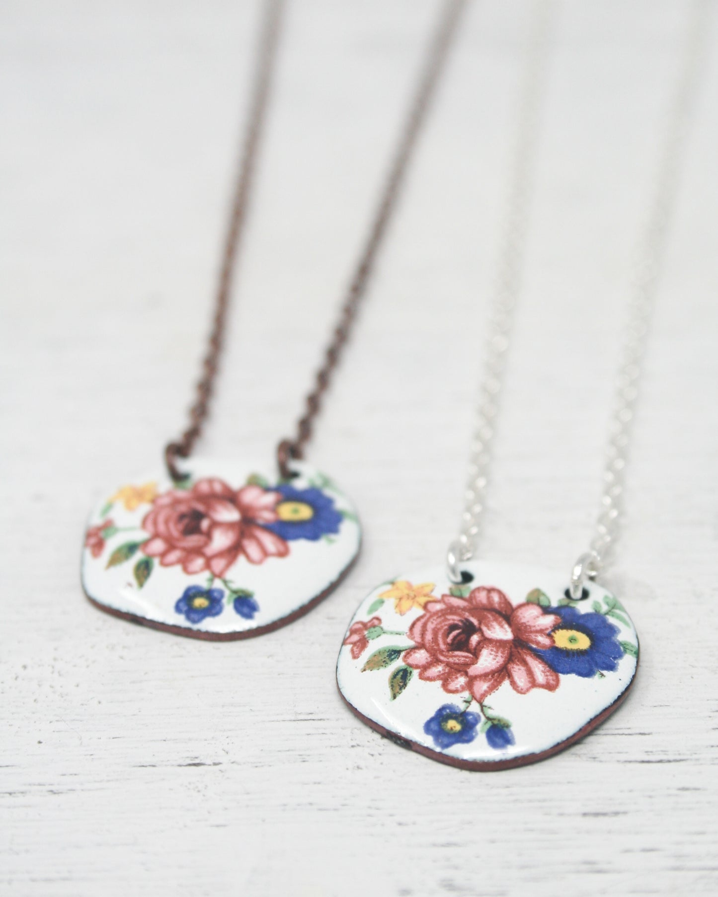 a couple of necklaces with flowers on them