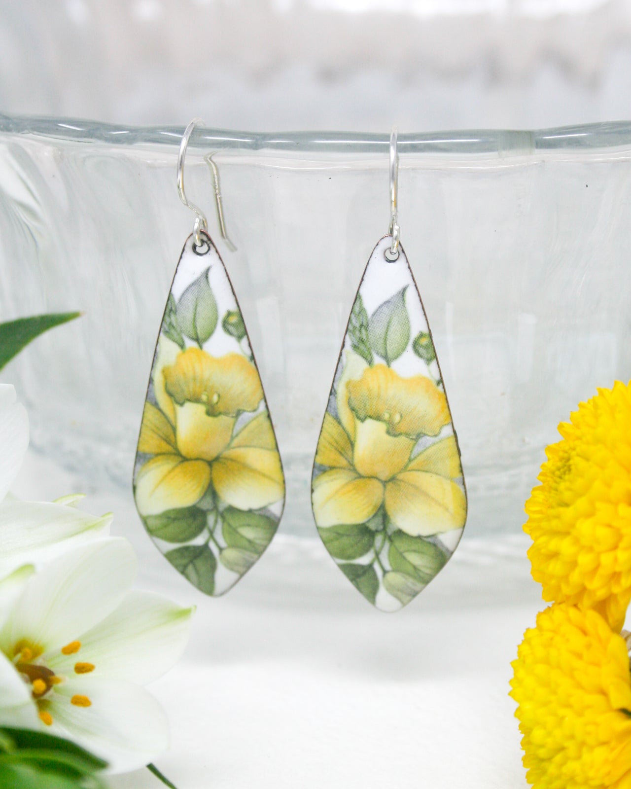 a pair of earrings with flowers painted on them