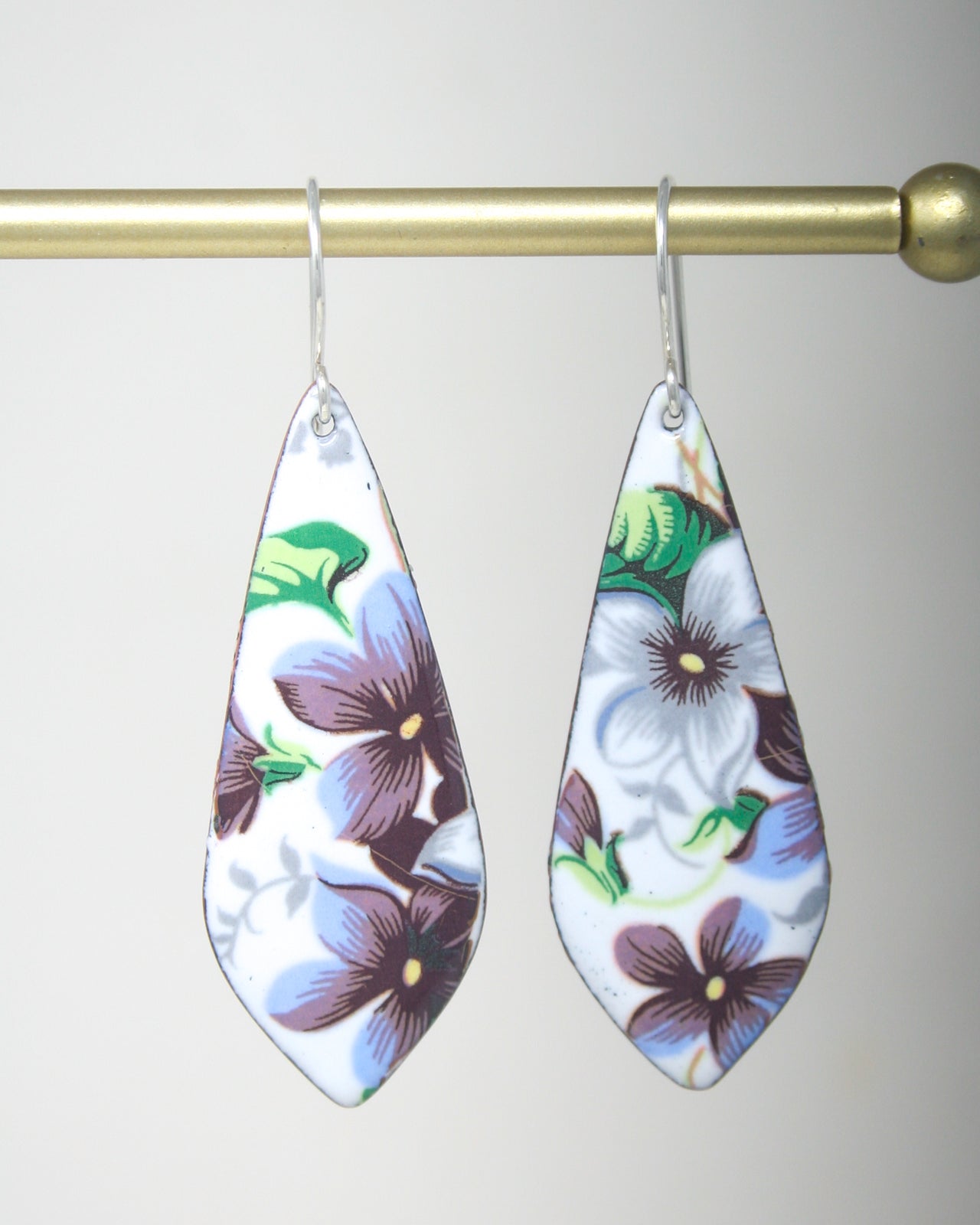 a pair of earrings hanging from a hook