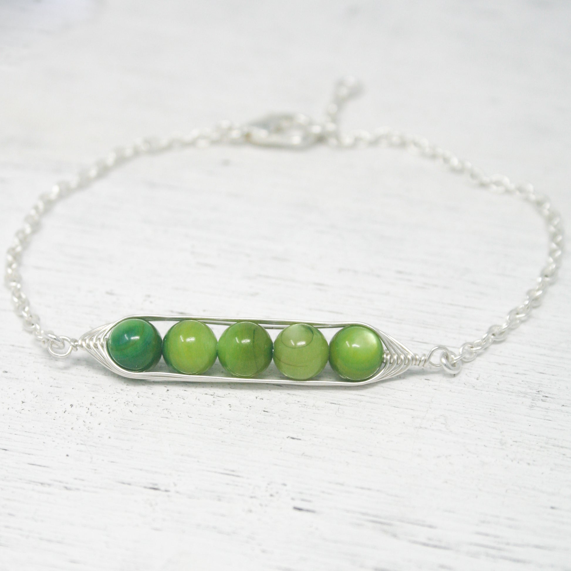 a green beaded bracelet on a white table
