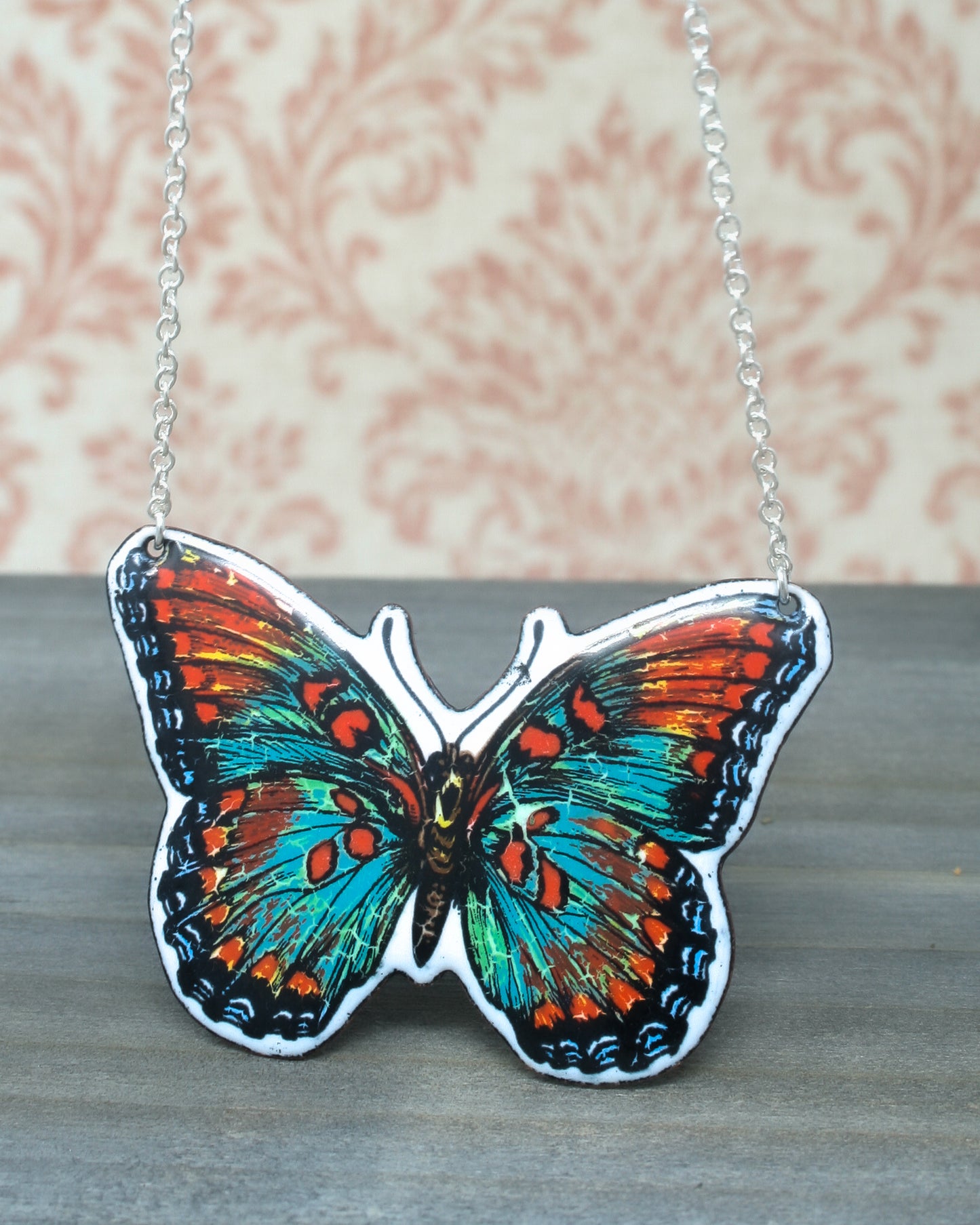 a colorful butterfly is hanging from a chain