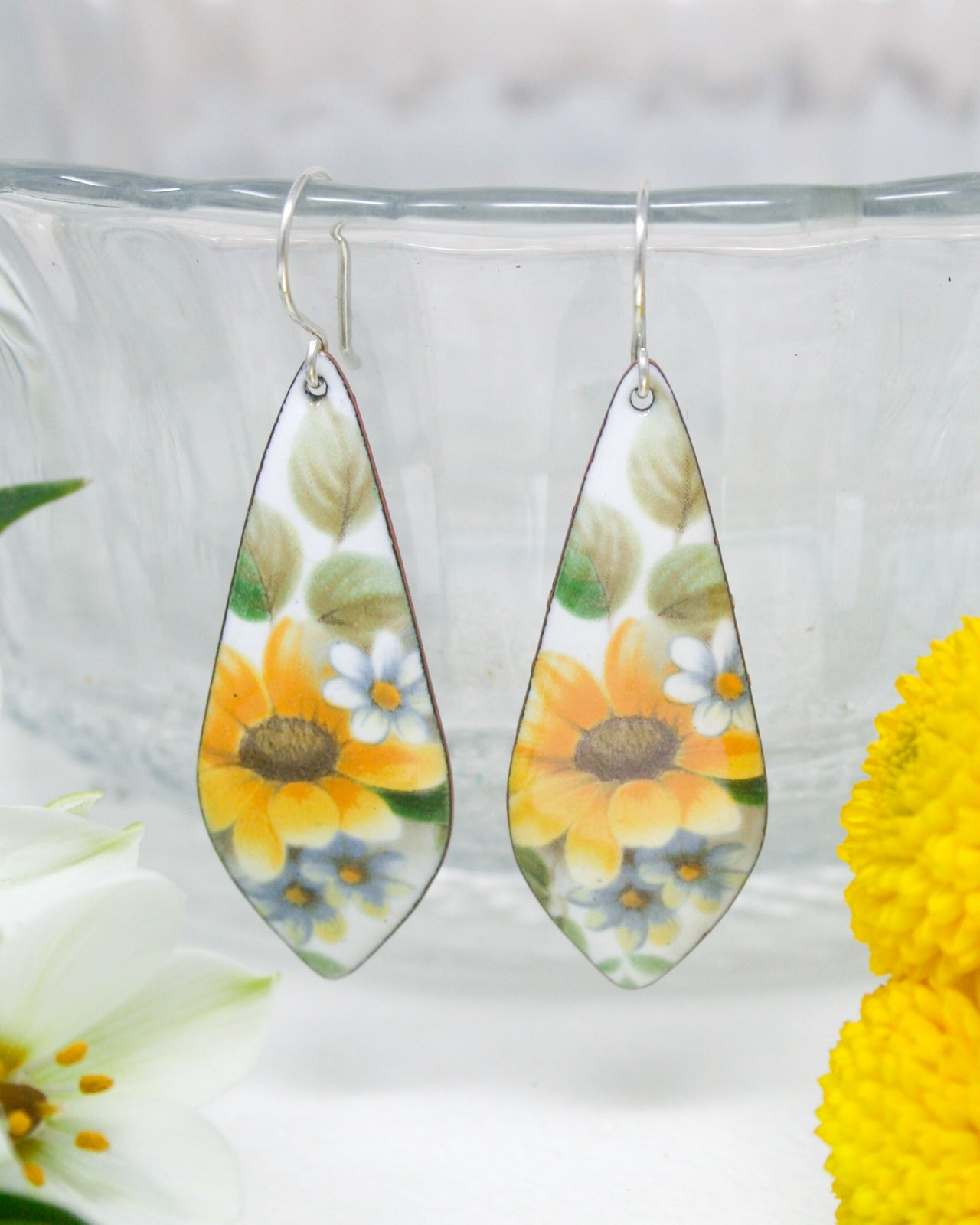 a pair of earrings with flowers painted on them