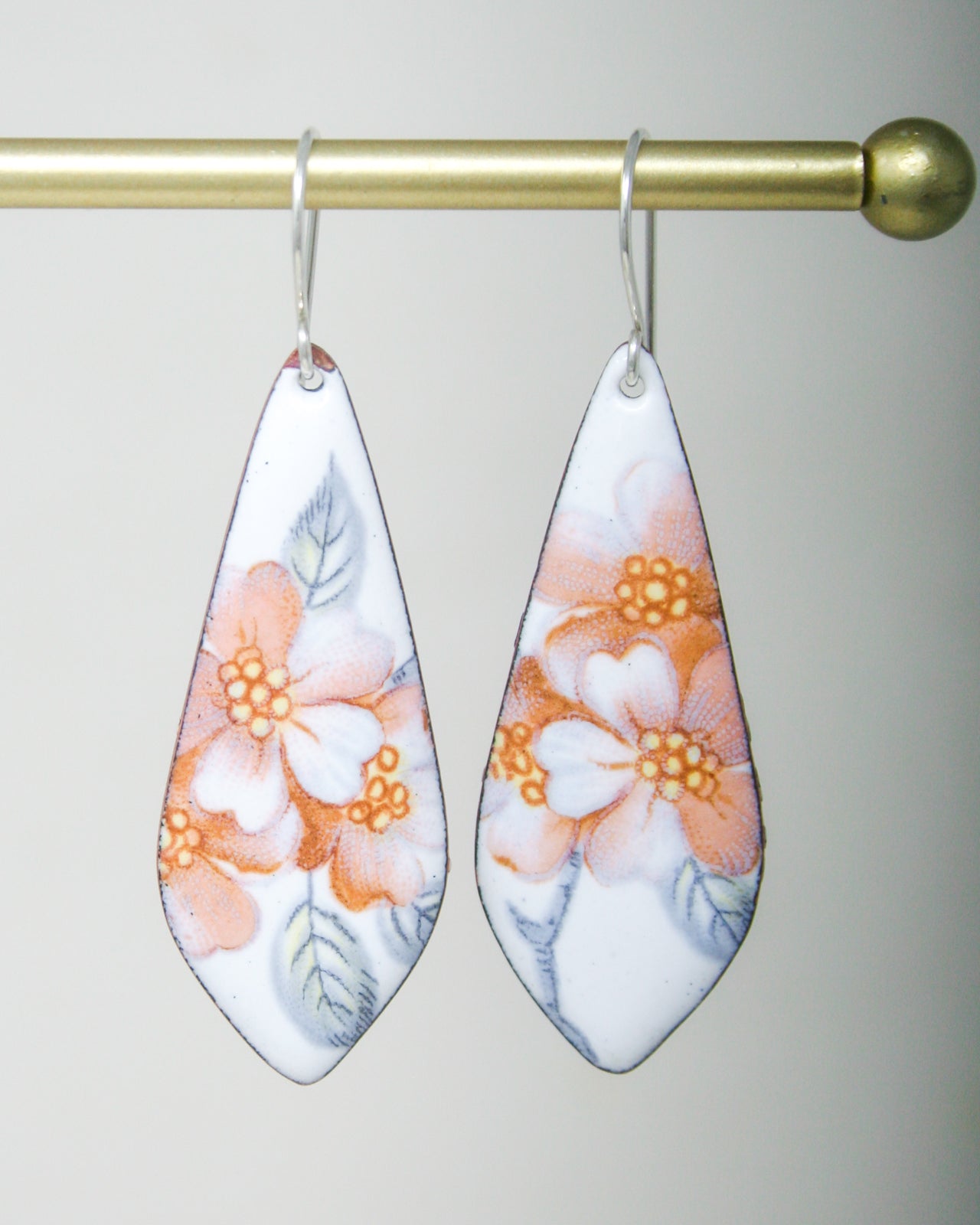 a pair of earrings hanging from a hook