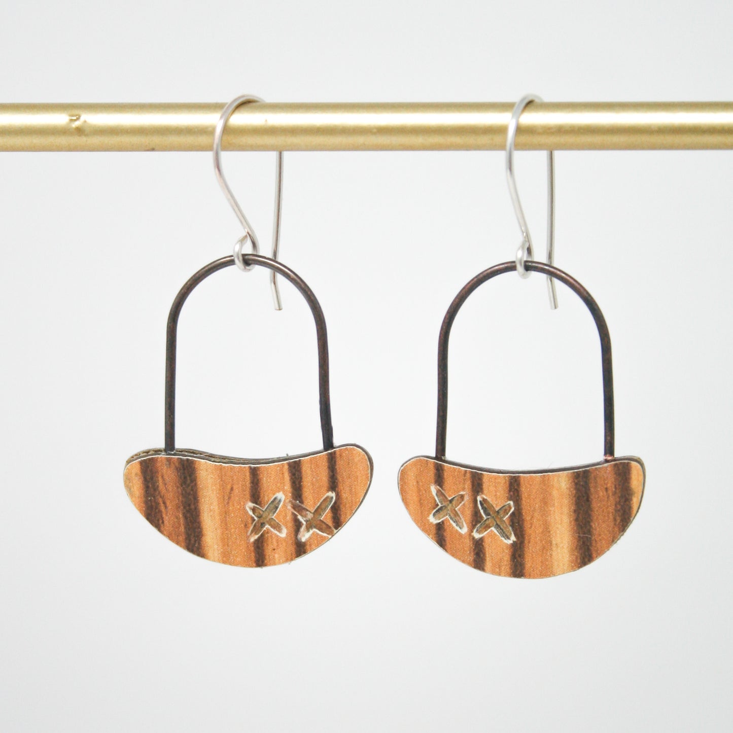 a pair of wooden earrings hanging from a hook