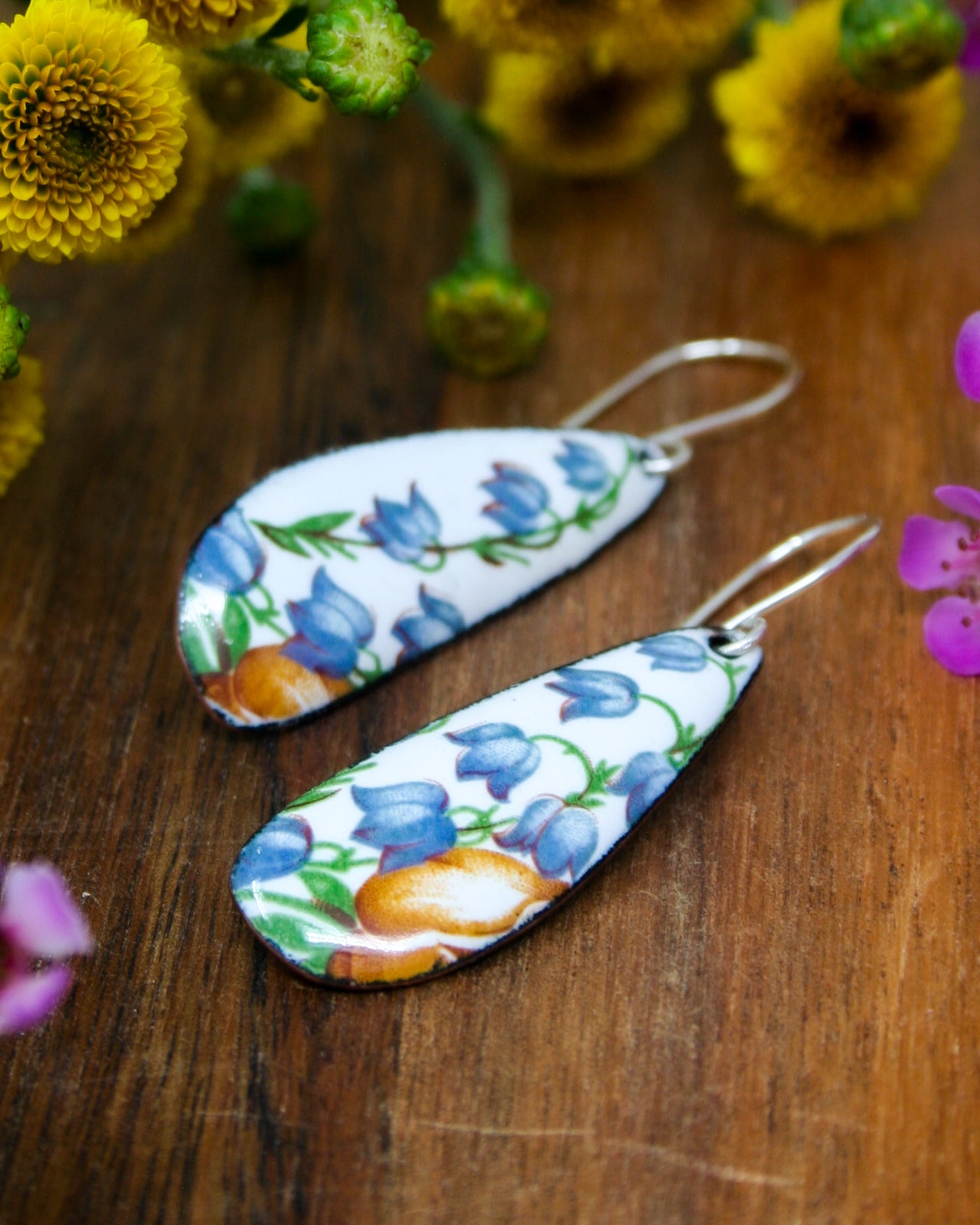 a pair of earrings sitting on top of a wooden table