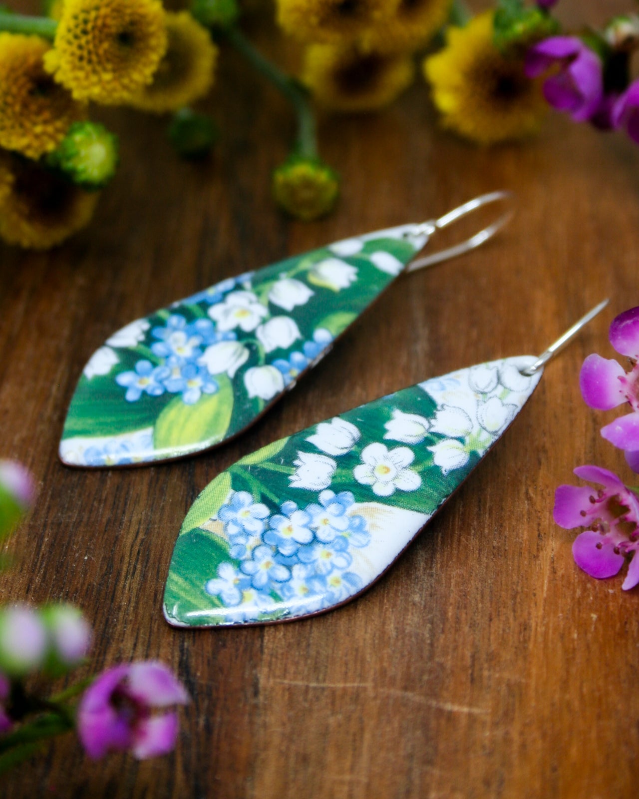 a pair of earrings sitting on top of a wooden table