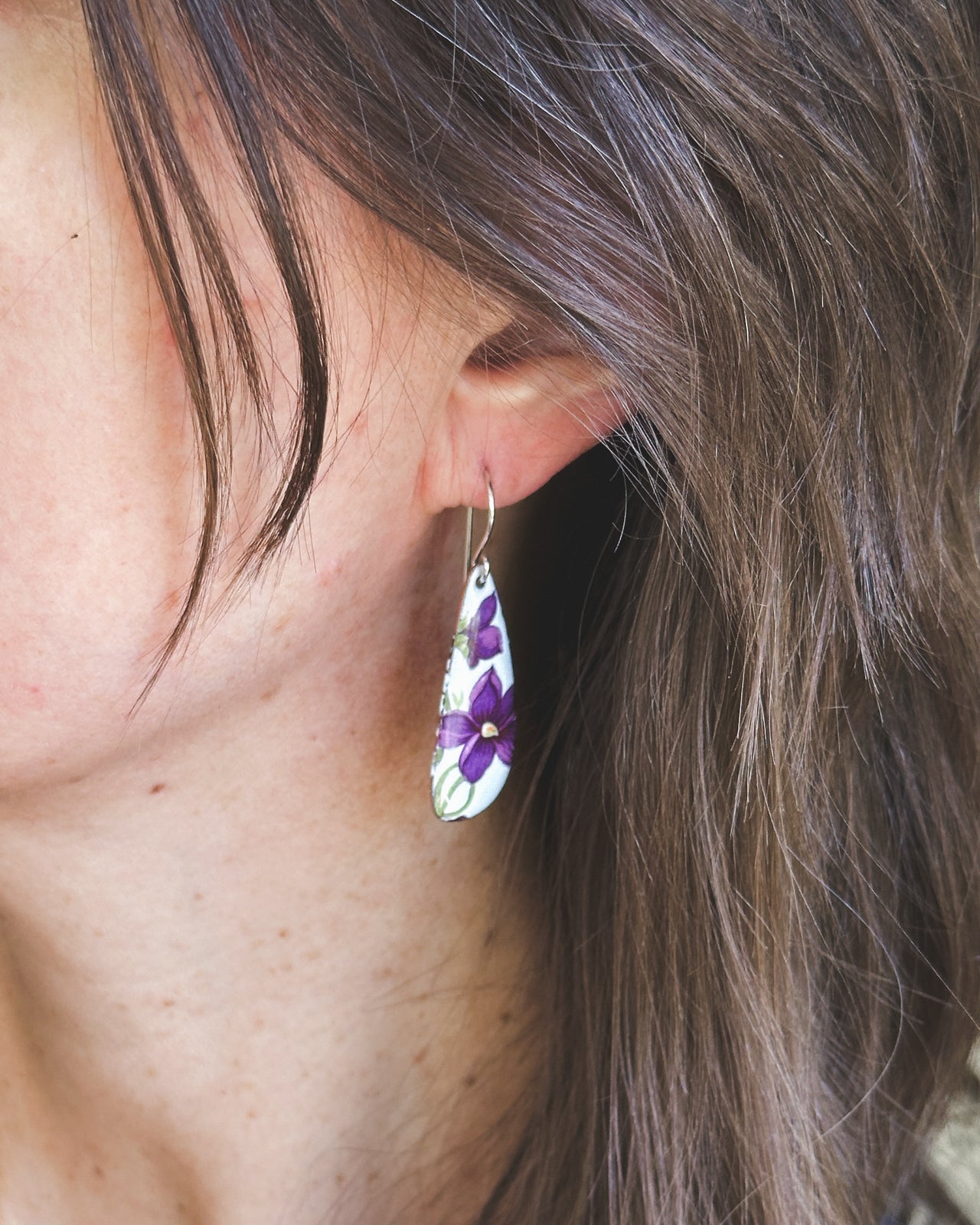 a close up of a person wearing a pair of earrings