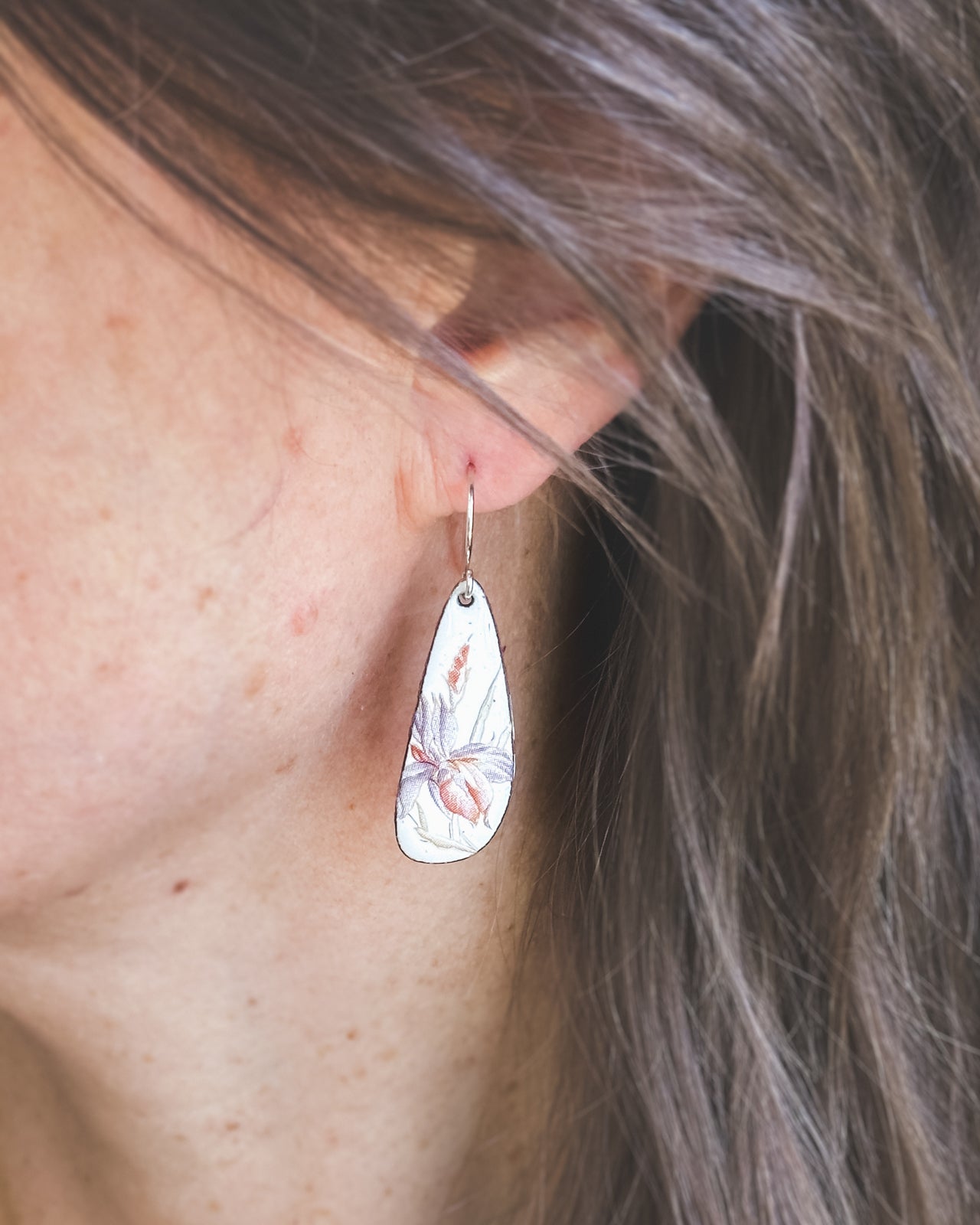 a close up of a person wearing a pair of earrings