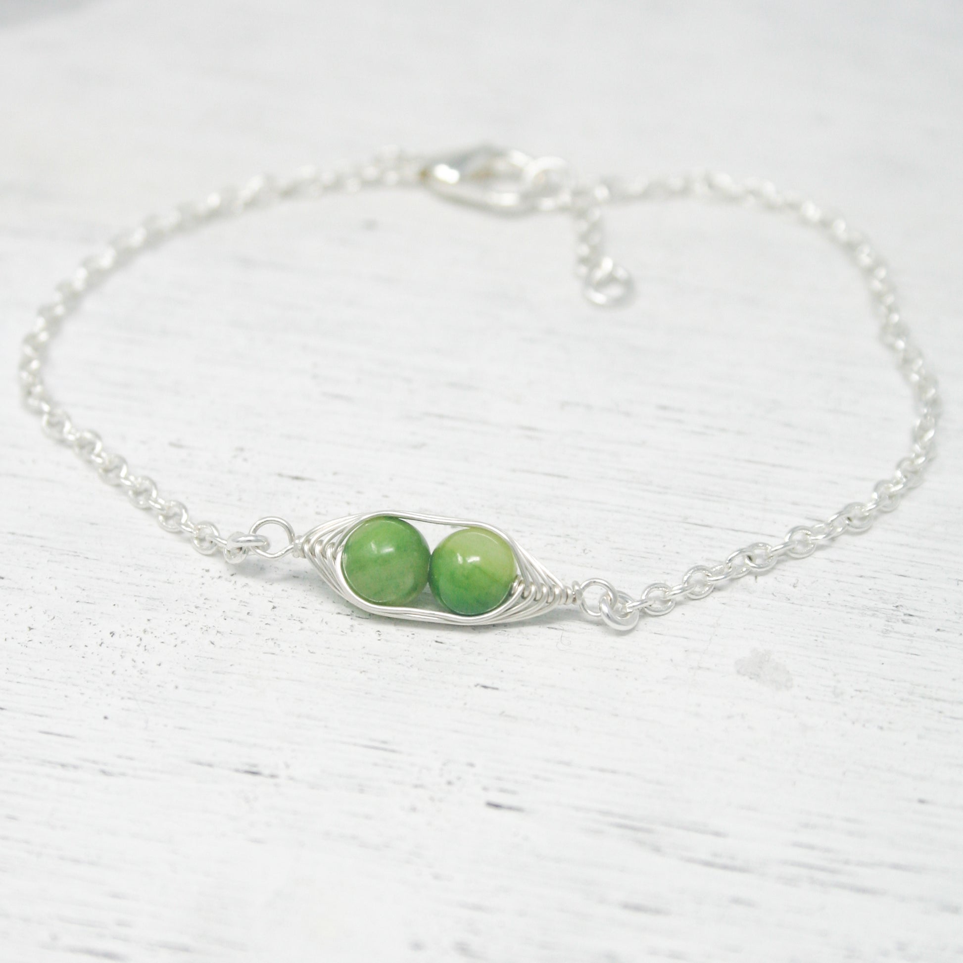 two peas on a silver chain bracelet