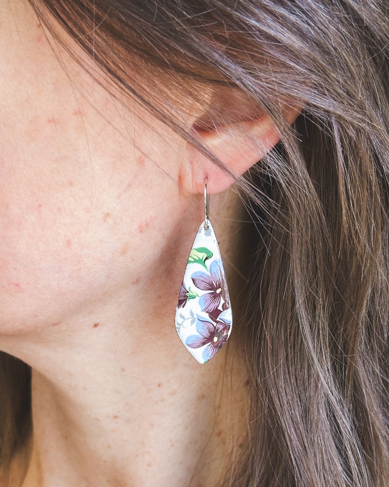 a close up of a person wearing a pair of earrings