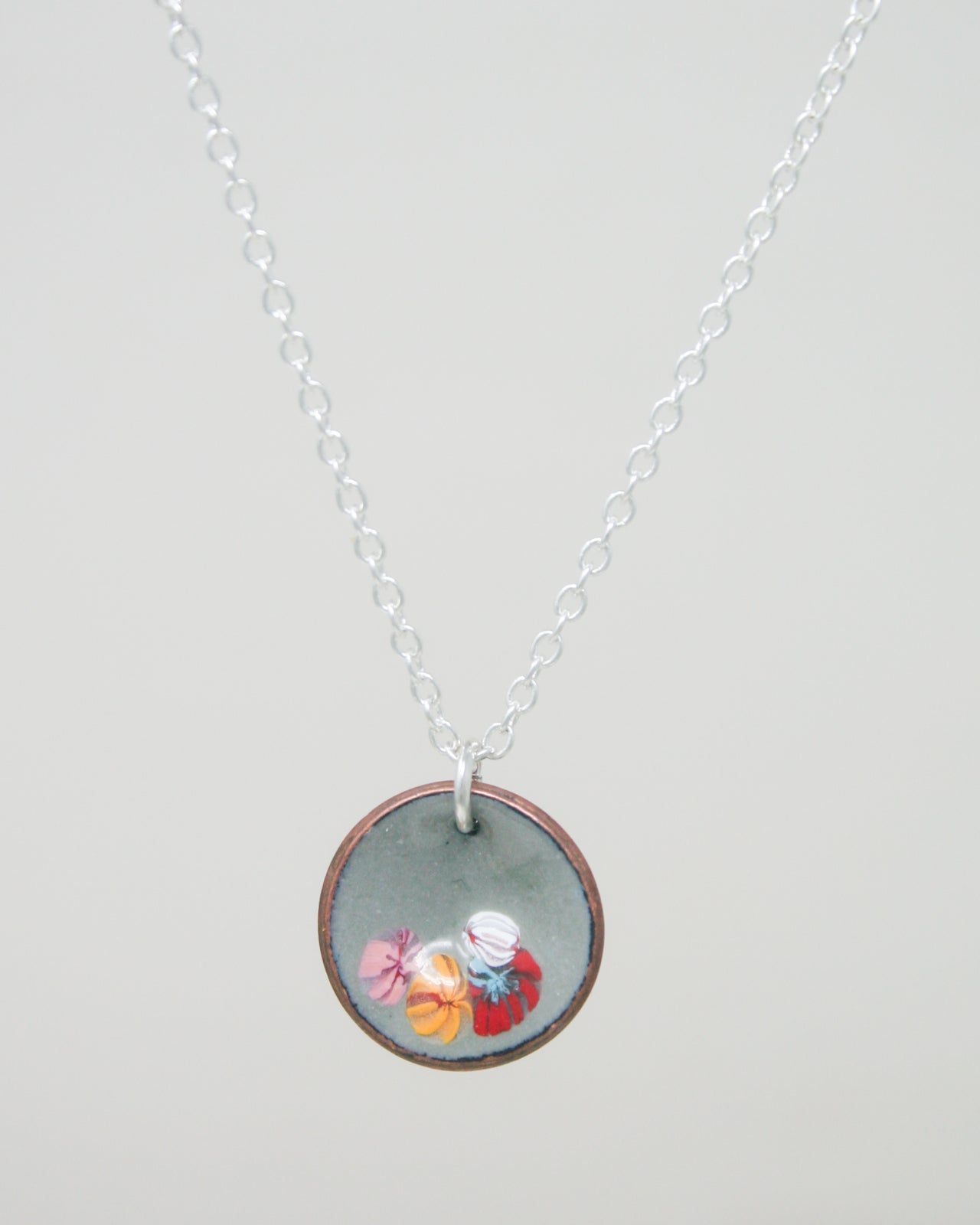 a necklace with a picture of a cupcake on it