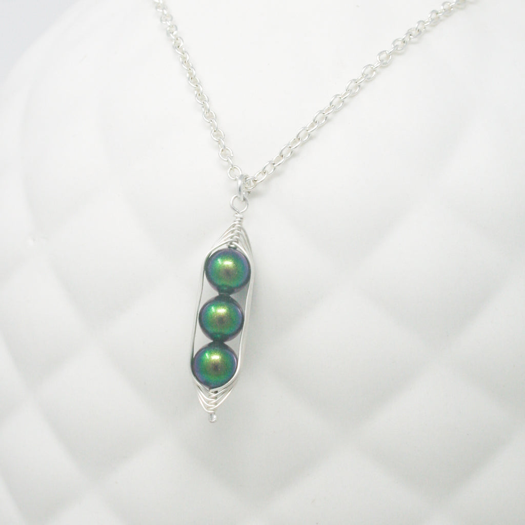 three peas in a pod shaped pendant on a chain