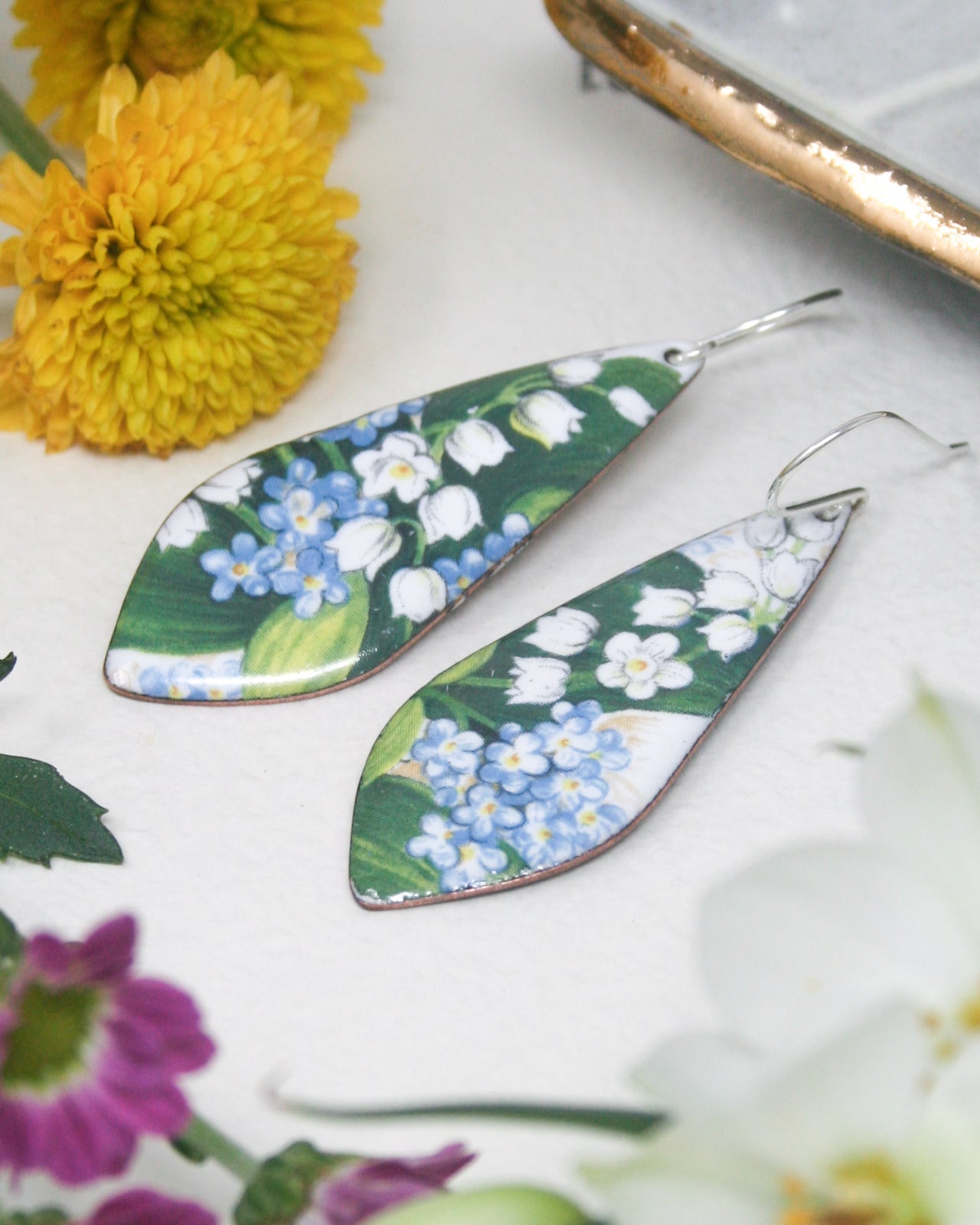 a pair of earrings with flowers on them