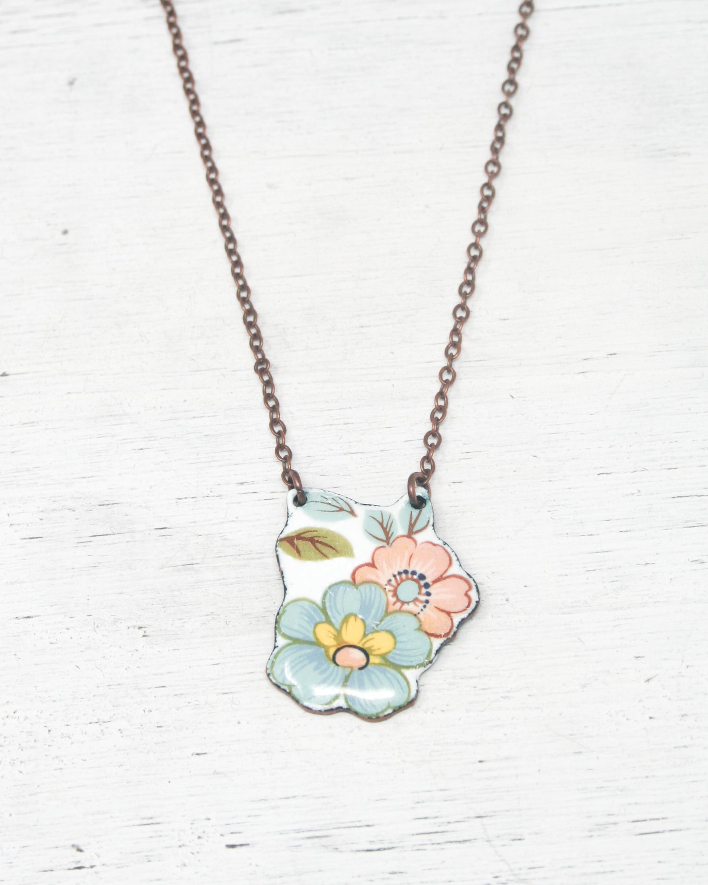 a necklace with a flower painted on it
