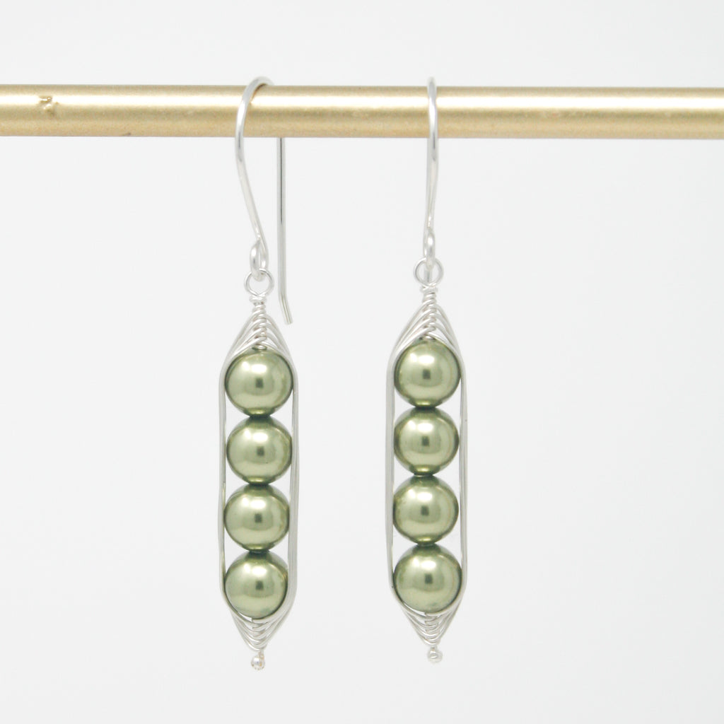 a pair of earrings with pearls hanging from them