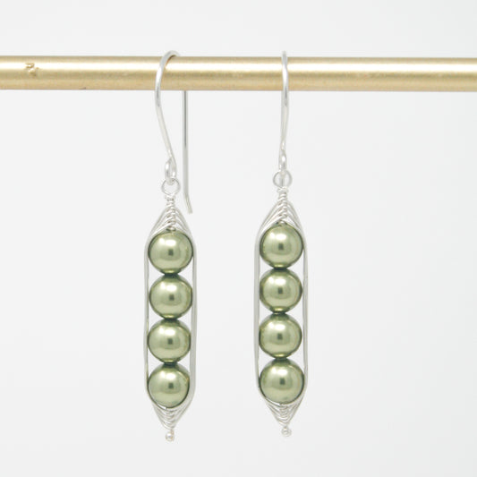 a pair of earrings with pearls hanging from them