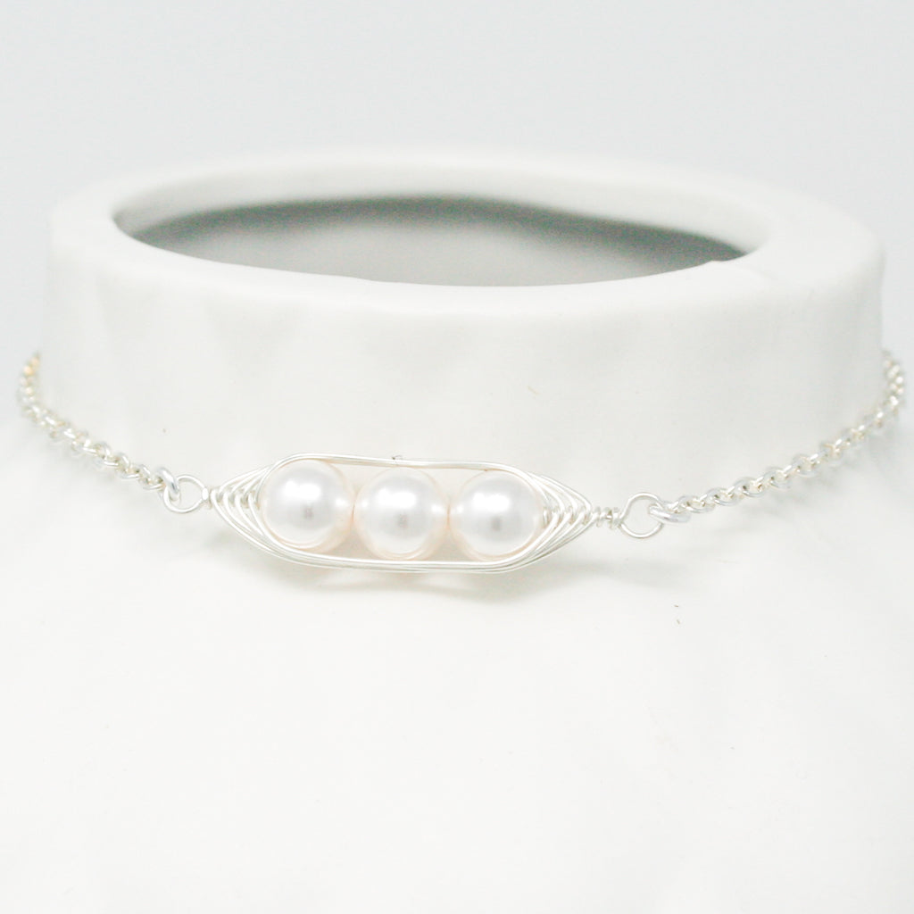 a white necklace with two pearls attached to it