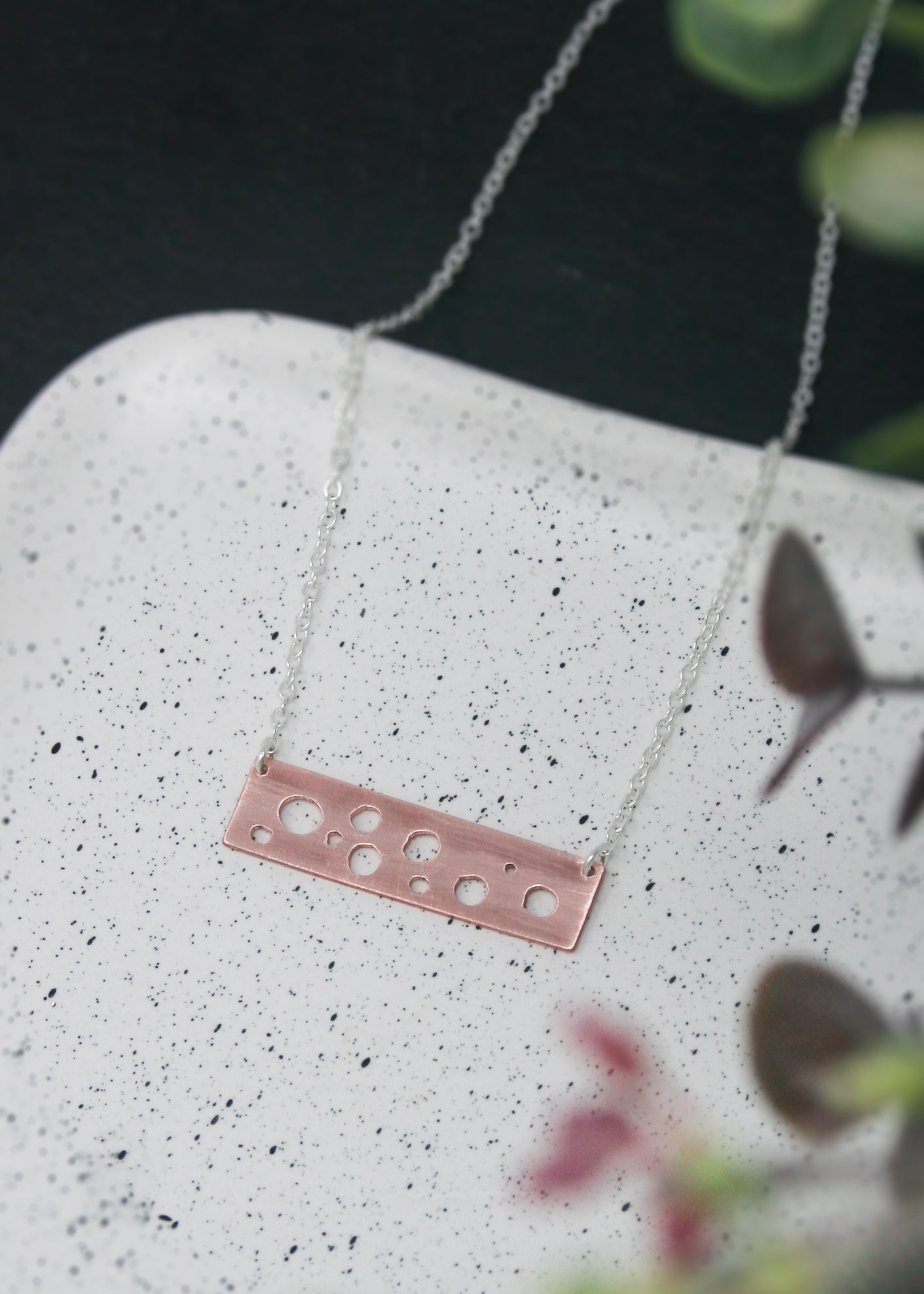 a necklace with three holes on it sitting on a plate