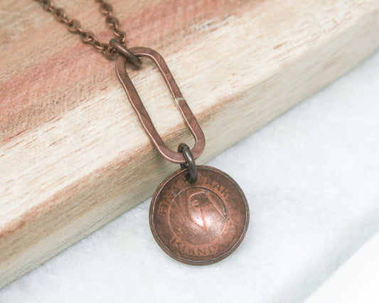 a necklace with a coin hanging from a chain