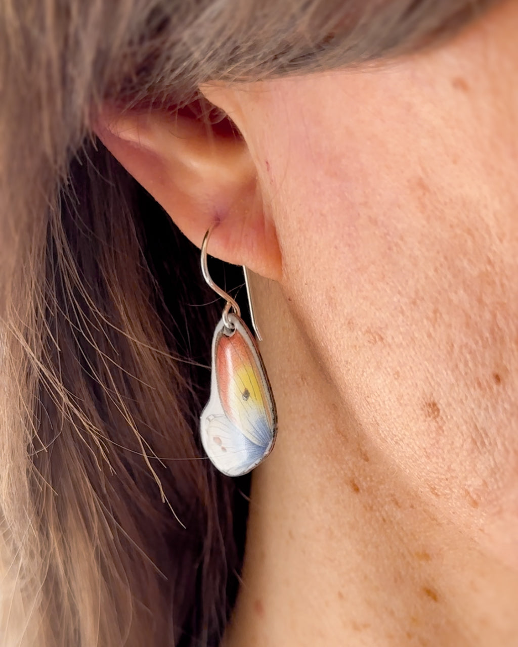 a close up of a person wearing a pair of earrings