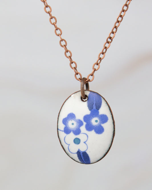 A necklace with a pendant featuring a blue floral design.
