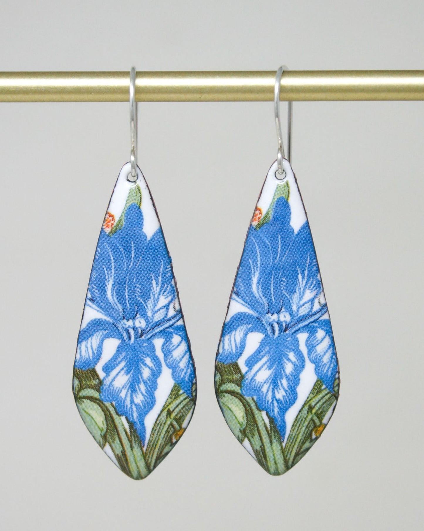 A pair of earrings with a blue floral pattern on a white background.
