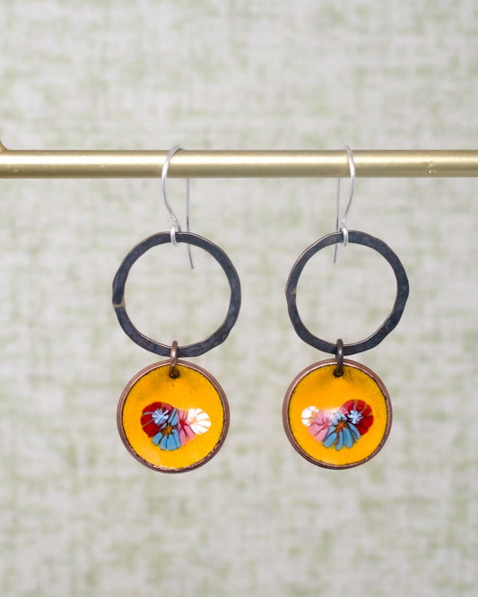 a pair of earrings hanging from a hook