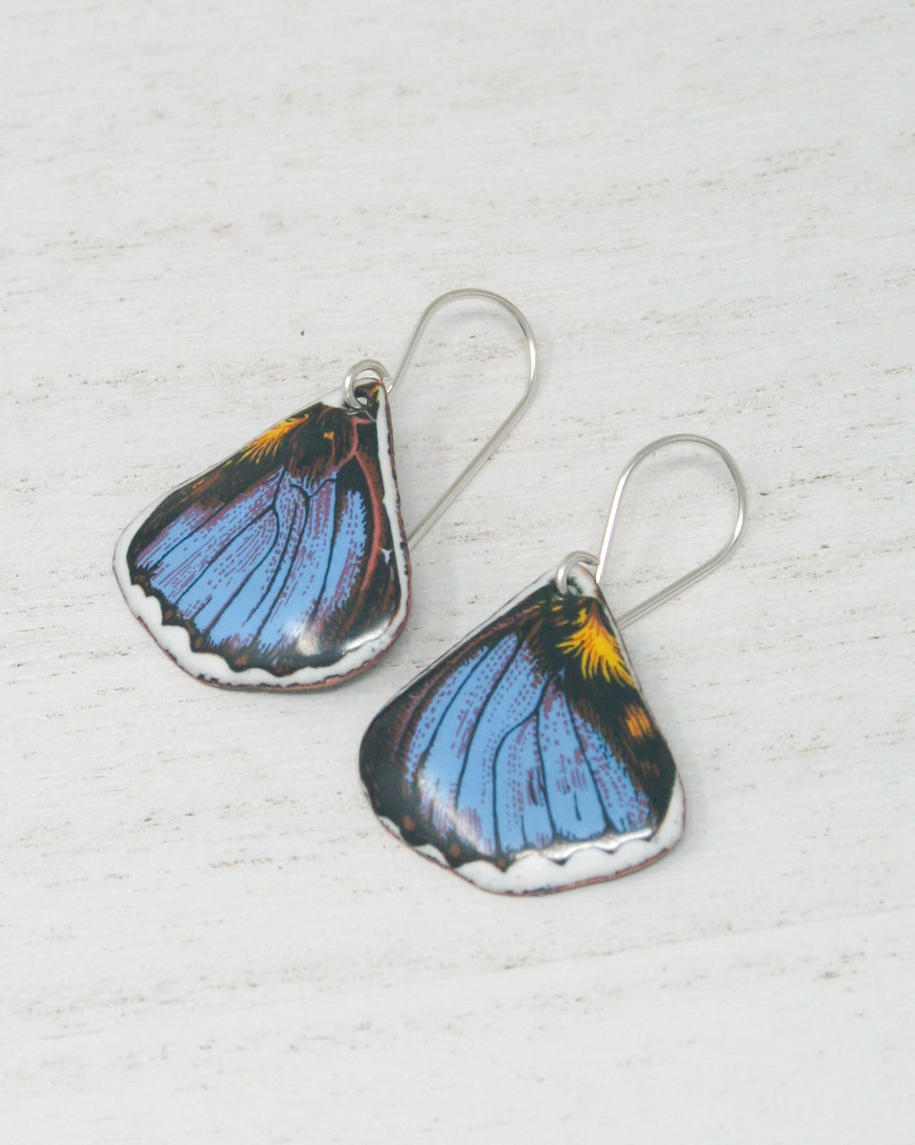 a pair of blue and yellow butterfly earrings