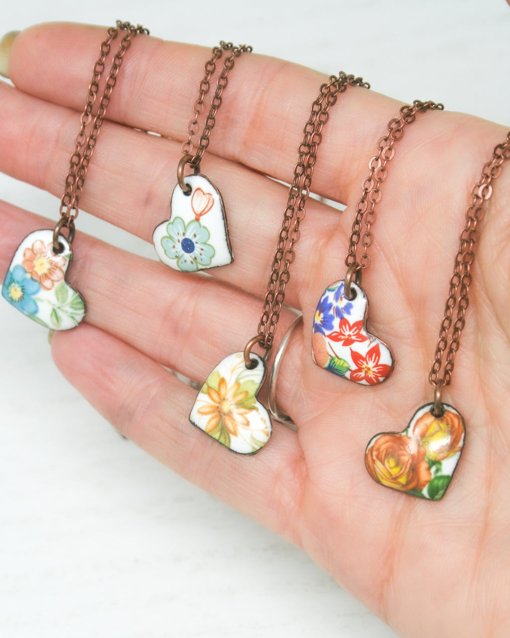 a hand holding a bunch of different shaped necklaces