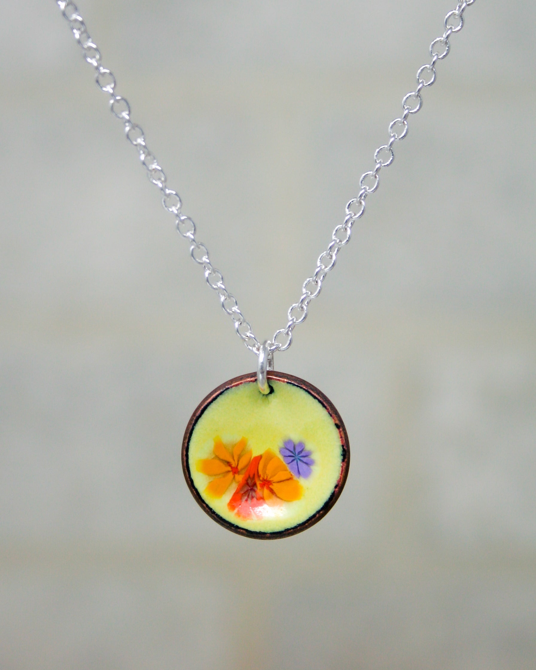 a necklace with a picture of a flower on it