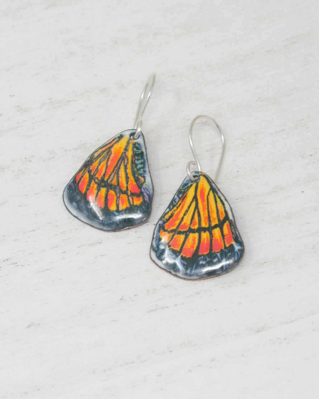 a pair of earrings with a butterfly design on them