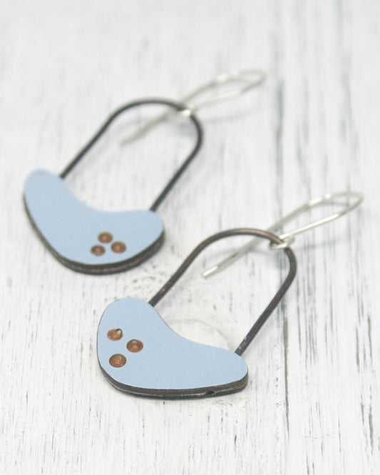 A pair of blue earrings with three small circular stones on the surface.