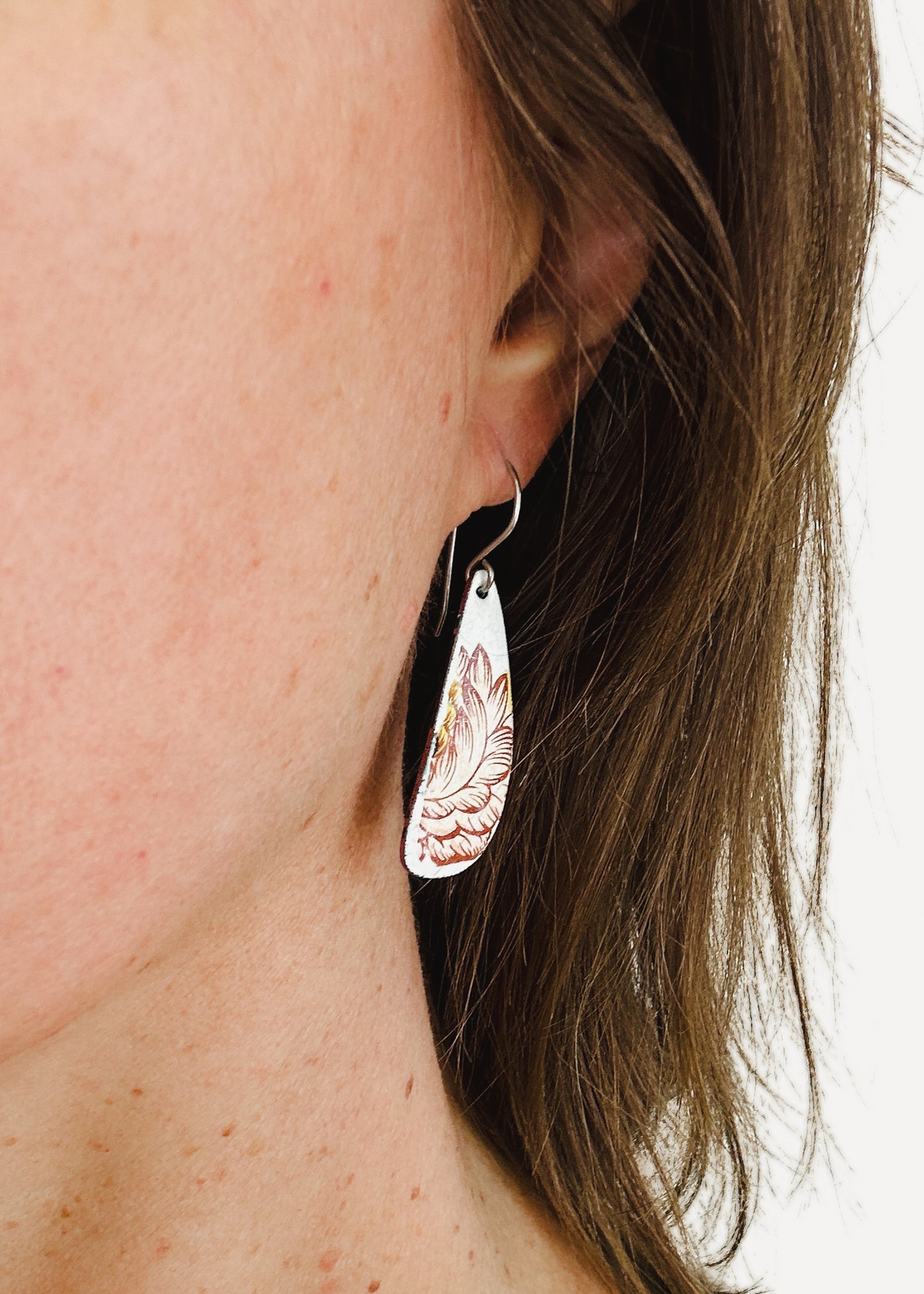 a close up of a person wearing a pair of earrings